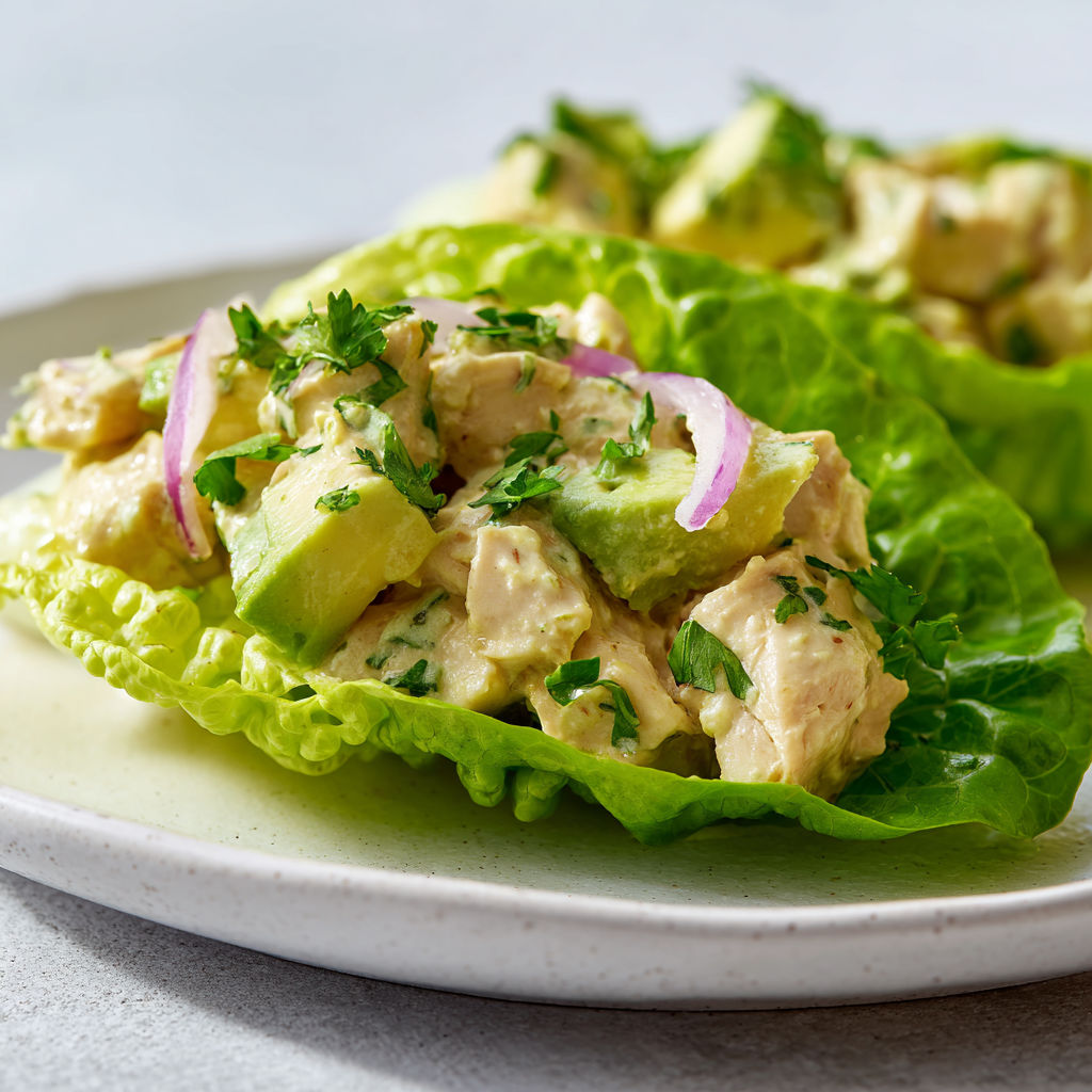 Un plat de laitue garnie de poulet et d’herbes vertes.