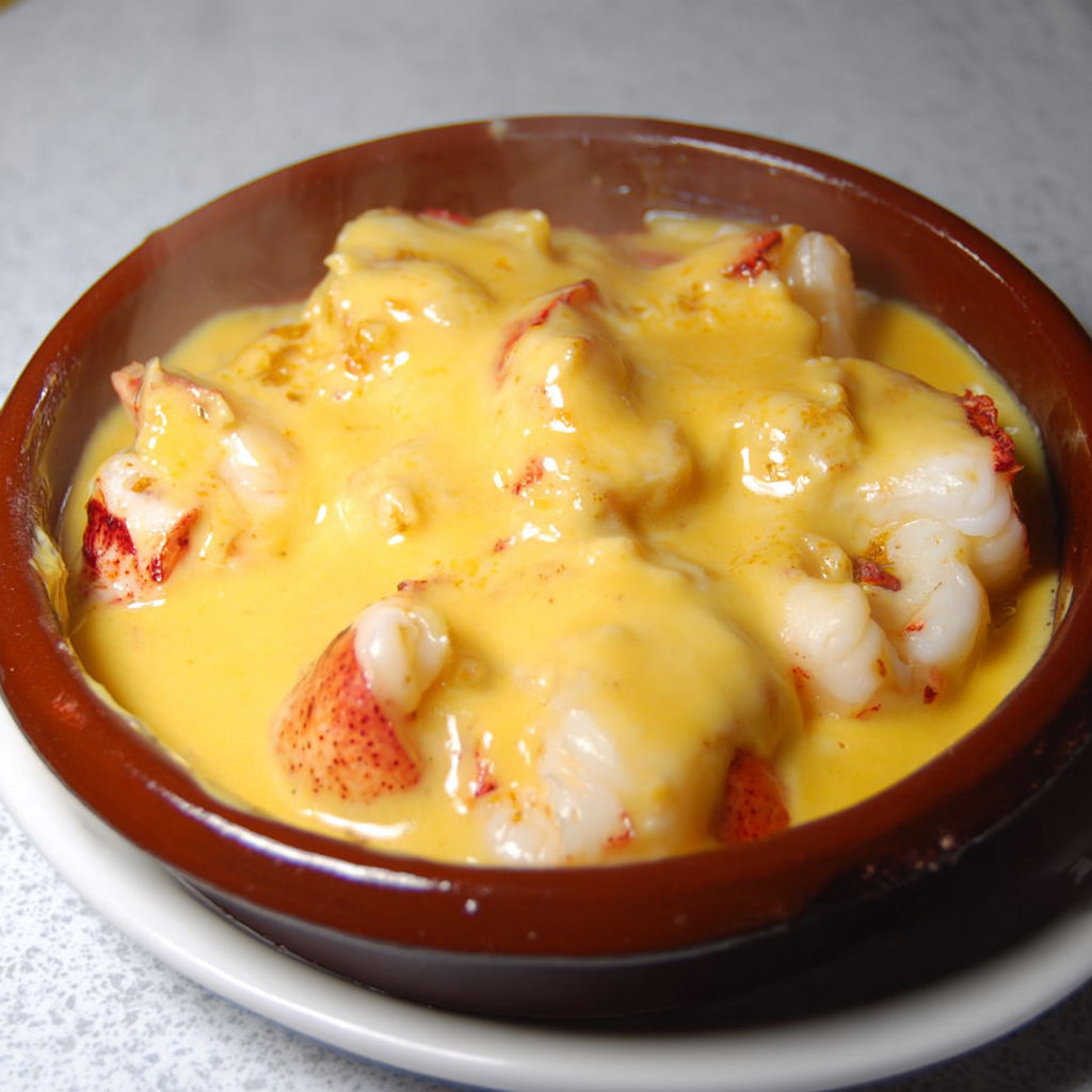 Petit bol en terre avec une sauce riche et morceaux de fruits de mer.