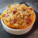 Un gratin composé de courge mixée, lardons, et recouvert d'un crumble doré