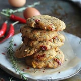 Une pile de biscuits garnis de légumes grillés et d'herbes fraîches sur un joli plat.