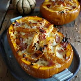 Deux moitiés de courges garnies de fromage fondant, lardons et légumes, disposées sur une assiette élégante.