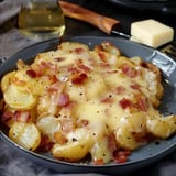 Un plat montagnard de pommes de terre dorées, fromage reblochon fondu et lardons croustillants servis dans un plat rustique.