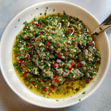 Un bol de sauce aux herbes fraîches avec des touches de piment et une huile d'olive brillante.