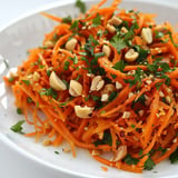 Salade de carottes râpées garnie de cacahuètes et herbes fraîches.