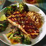 Filet de saumon grillé accompagné de légumes verts et noix croquantes.