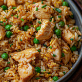 Un bol de riz frit avec du poulet pour un plat d’inspiration asiatique.