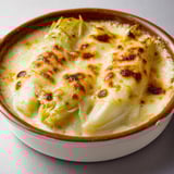 Un délicieux gratin d'endives fondantes et fromage doré dans un bol.