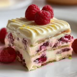 Une part élégante de lasagne sucrée au chocolat blanc et framboise, surmontée de fruits rouges.