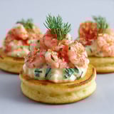 Blinis dorés avec crevettes fraîches et sauce légère citronnée parfumée à l’aneth.