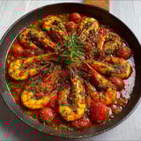 Poêlée de gambas à l’ail avec tomates et herbes fraîches du Sud.