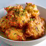 Assiette garnie de savoureux beignets de morue croustillants et maison.