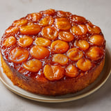 Un beau gâteau doré garni d'abricots sur un plat.