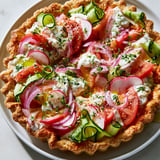 Un plat avec une tarte croustillante aux légumes colorés est présenté.