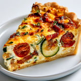 Un plat croustillant de quiche estivale aux courgettes et tomates juteuses.